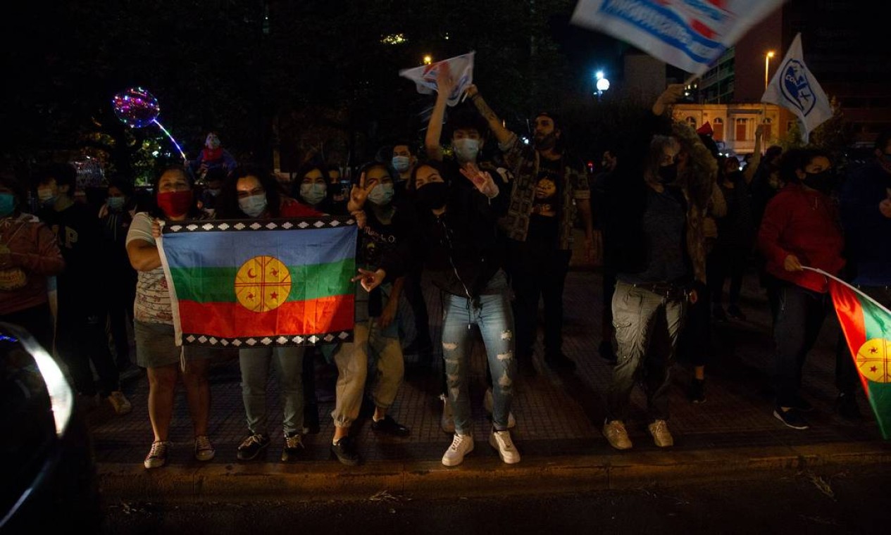 Manifestantes seguram bandeira Mapuche, que representa os povos originários e ganhou significado da luta popular, em Santiago Foto: CLAUDIO REYES / AFP