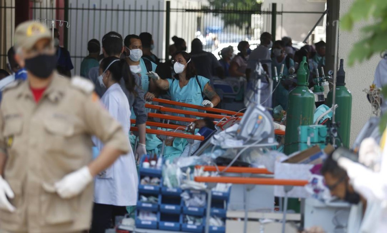 Funcionários do hospital ajudam bombeiros no resgate de pacientes Foto: Fabiano Rocha / Agência O Globo