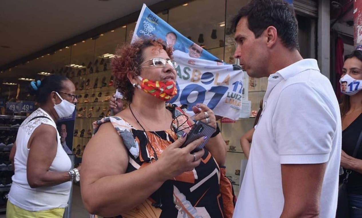 Luiz Lima (PSL), sem usar máscara, conversa próximo à eleitora que está com a máscara no queixo, durante caminhada em Madureira Foto: Reprodução / Redes Sociais - 27/10/2020