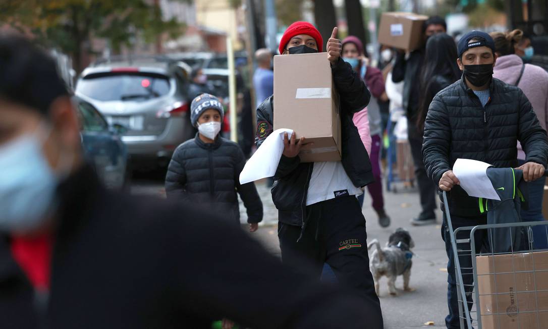 Moradores pegam caixas em centro de distribuição de comida em Nova York Foto: Michael M. Santiago / AFP