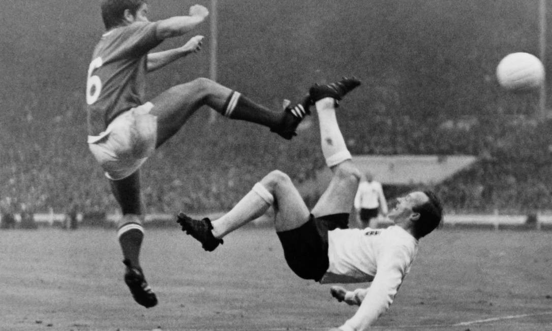 Em 20 de julho de 1966, o francês Robert Budzynski (à esquerda) chuta a bola contra o inglês Nobby Stiles (à direita) durante a partida da Copa do Mundo entre França e Inglaterra no Estádio de Wembley, em Londres.  Nobby Stiles, campeão da Copa do Mundo de 1966, morreu em 30 de outubro de 2020 aos 78 anos. Foto: STRINGER / AFP