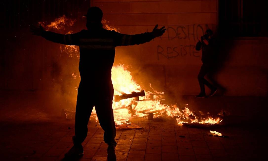 Manifestantes fazem fogueira em protesto contra as medidas restritivas em Barcelona Foto: JOSEP LAGO / AFP