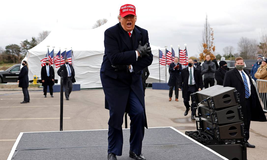 Donald Trump reage ao frio e ao vento durante um comício de campanha em Michigan Foto: CARLOS BARRIA / REUTERS