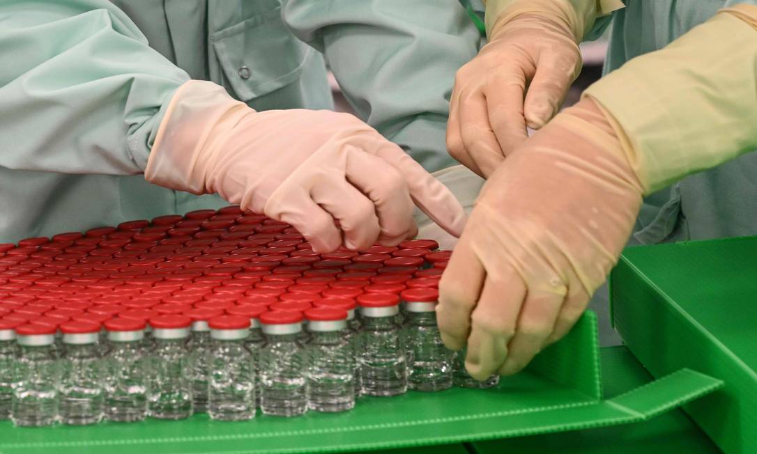 Técnicos de laboratório trabalham com testes da vacina da Universidade de Oxford Foto: VINCENZO PINTO / AFP