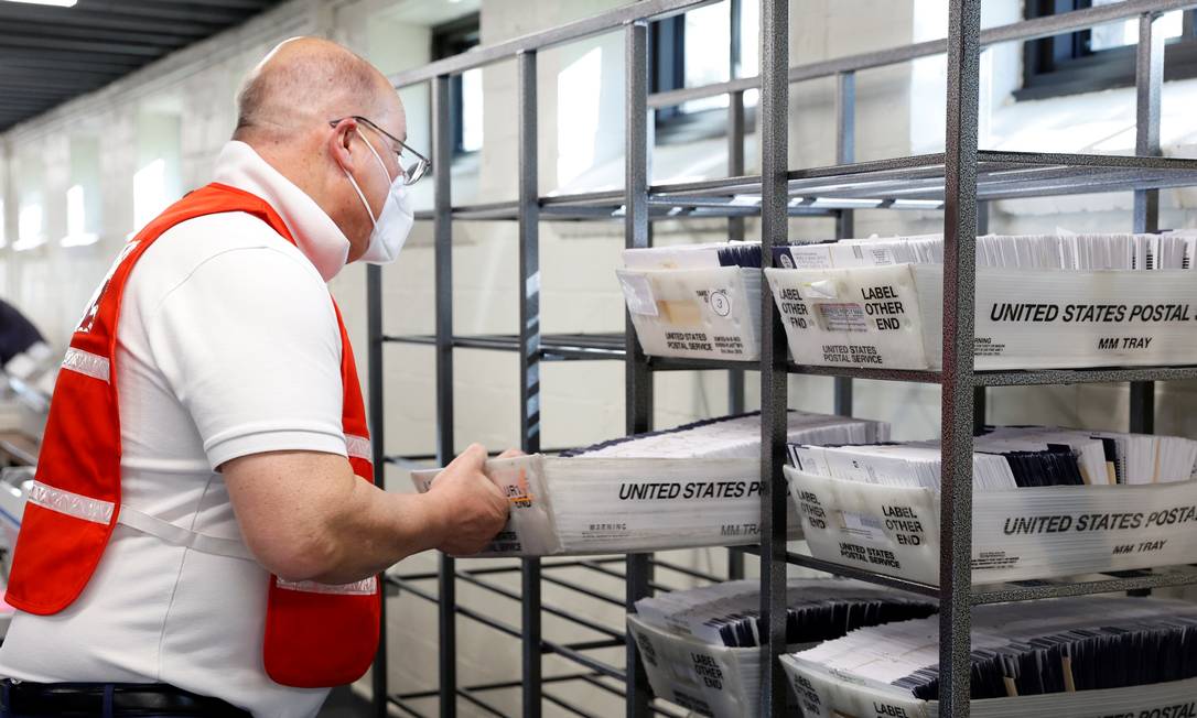Funcionário do condado de Chester, na Pensilvânia, leva cédulas enviadas por correio para contagem Foto: RACHEL WISNIEWSKI / REUTERS