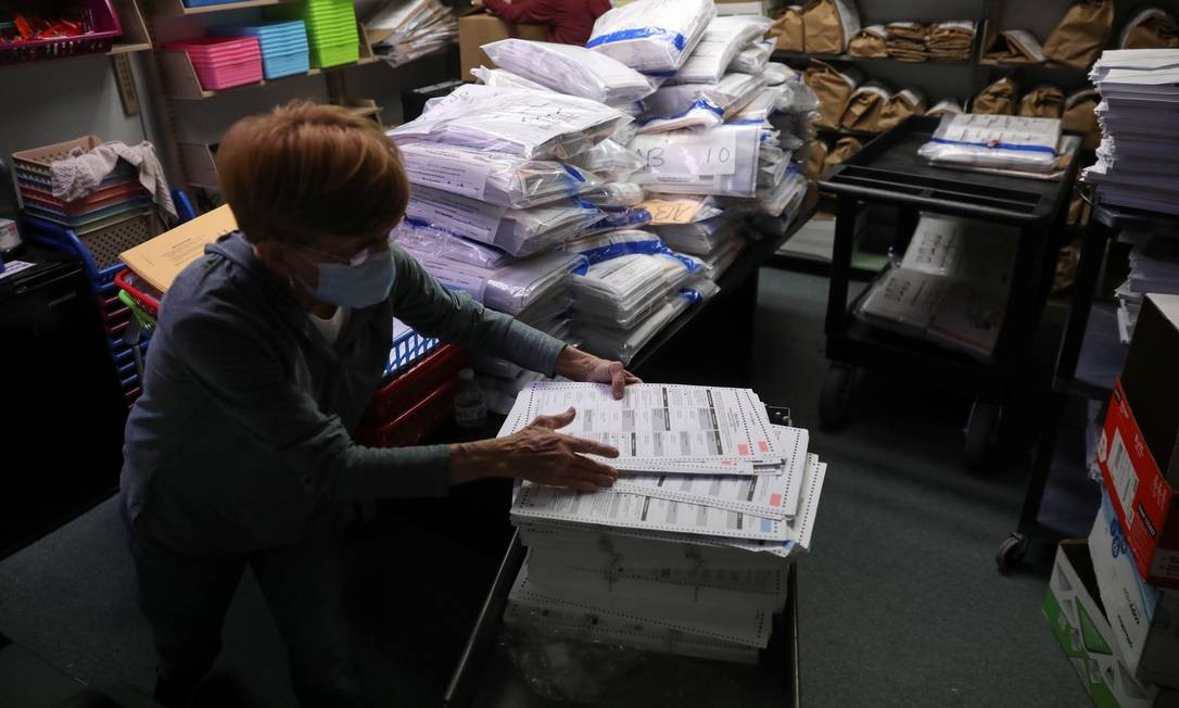 Uma oficial eleitoral trabalha na sala de votação organizando cédulas não utilizadas devolvidas da zona eleitoral após o dia da eleição em Kenosha, Wisconsin Foto: DANIEL ACKER / REUTERS