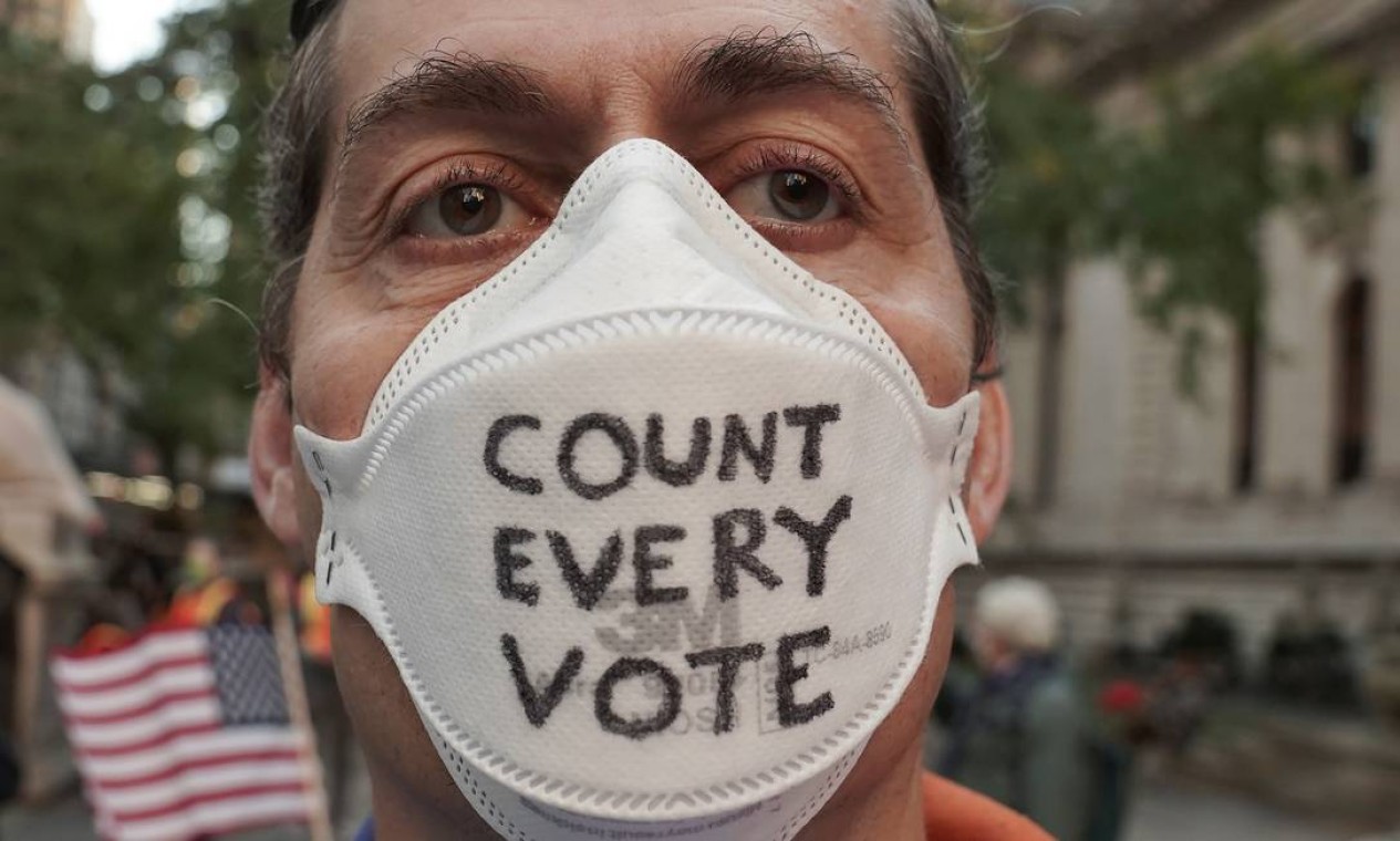 Um homem usa uma máscara com lema do ato "Conte todos os votos" no bairro de Manhattan, na cidade de Nova York Foto: CARLO ALLEGRI / REUTERS