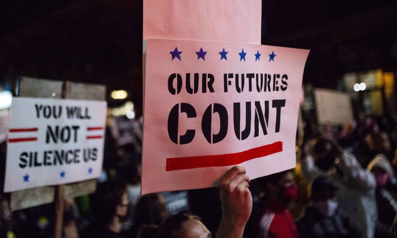 "Nosso futuro importa" e "Vocês não vão nos calar", dizem cartazes vistos na marcha na Cedar Avenue em Minneapolis, Minnesota, contra as tentativas do presidente Donald Trump de impedir a contagem das cédulas Foto: Stephen Maturen / AFP
