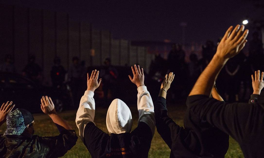 Pessoas confrontam a polícia quando fecham as ruas perto da I-94 em Minneapolis, Minnesota.  Centenas de pessoas foram presas por & # 034;  incômodo público & # 034;  Foto: Stephen Maturen / AFP