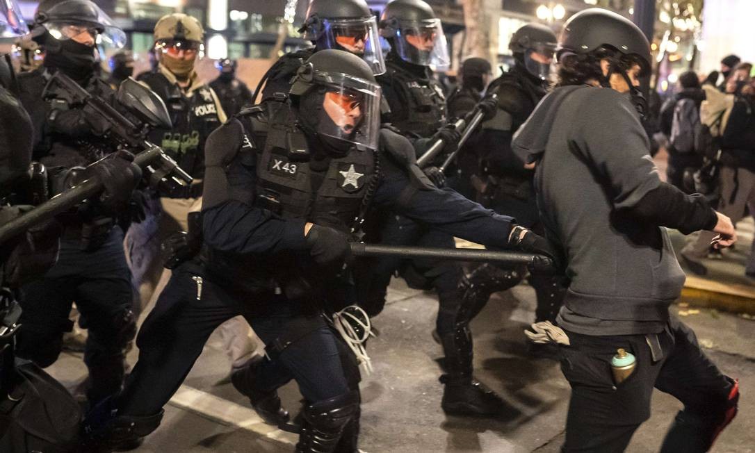 Tropas de choque espancaram o manifestante com um bastão enquanto dispersavam uma multidão de manifestantes do Black Bloc em Portland, Oregon.  Foto: Nathan Howard / AFP