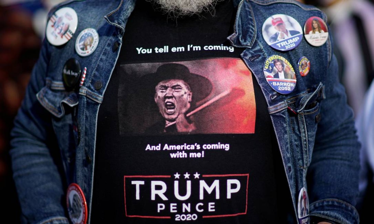 Um apoiador do presidente americano, vestindo uma camisa em que ele aparece atirando, aguarda os resultados das eleições enquanto os votos continuam a ser contados na Filadélfia, Pensilvânia Foto: EDUARDO MUNOZ / REUTERS