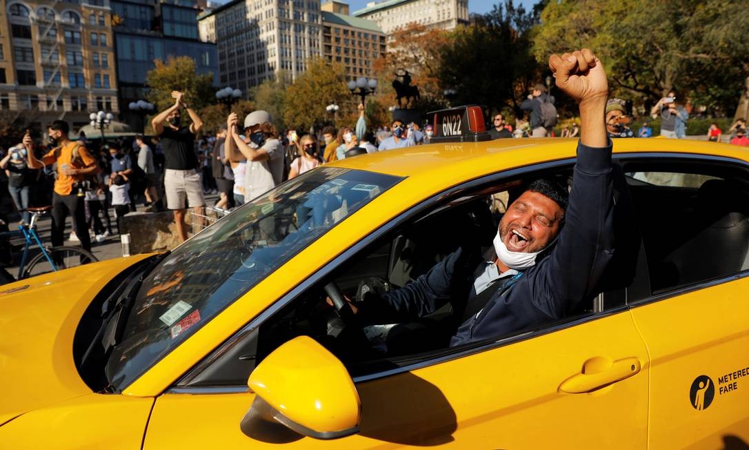 The taxi driver raises his fist and yells as people celebrate the announcement of the victory of Democratic candidate Joe Biden in Manhattan, New York.  Photo: ANDREW KELLY / REUTERS