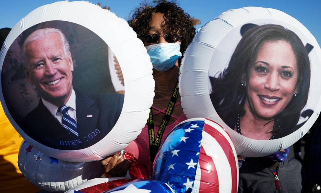 In Wilmington, Delaware, a supporter holds balloons with the faces of Biden and Congresswoman, Kamala Harris, the first woman elected to office in the US Photo: KEVIN LAMARQUE / REUTERS