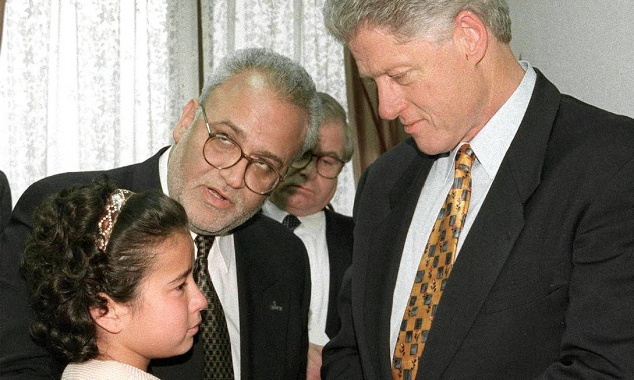 Erekat e o presidente dos EUA, Bill Clinton, consolam uma menina palestina depois que ela e três outras apelaram a Clinton e ao líder palestino, Yasser Arafat, pela libertação de seus pais das prisões israelenses, na cidade de Gaza Foto:   / AFP - 14/12/1998