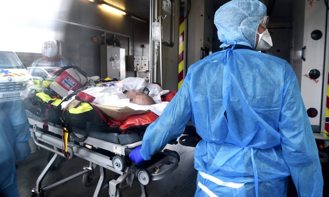 Equipe médica cuida de um paciente infectado com o novo coronavírus em sua chegada de helicóptero após ter sido transferido de Lyon para o Hospital Universitário de Strasbourg, leste da França Foto: FREDERICK FLORIN / AFP