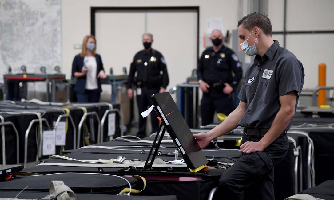 Funcionário do condado de Clark, em Nevada, inspeciona parte de uma urna eletrônica Foto: Ethan Miller / AFP