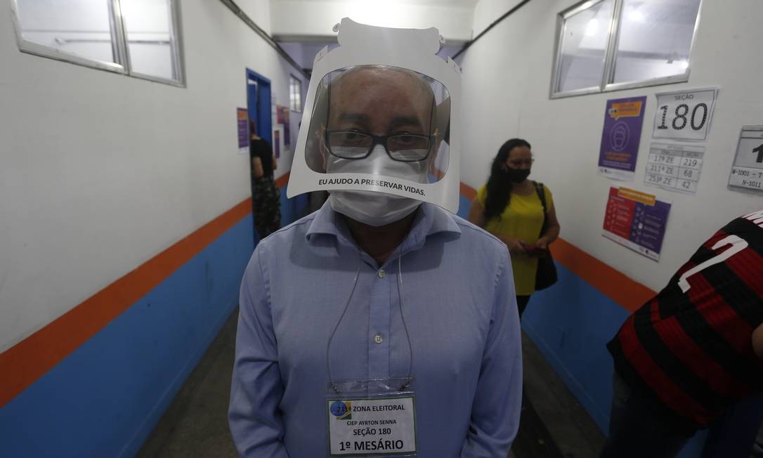 Um mesário trabalha usando face shield durante o domingo de votação no Ciep Ayrton Senna, na Rocinha Foto: Fabiano Rocha / Agência O Globo