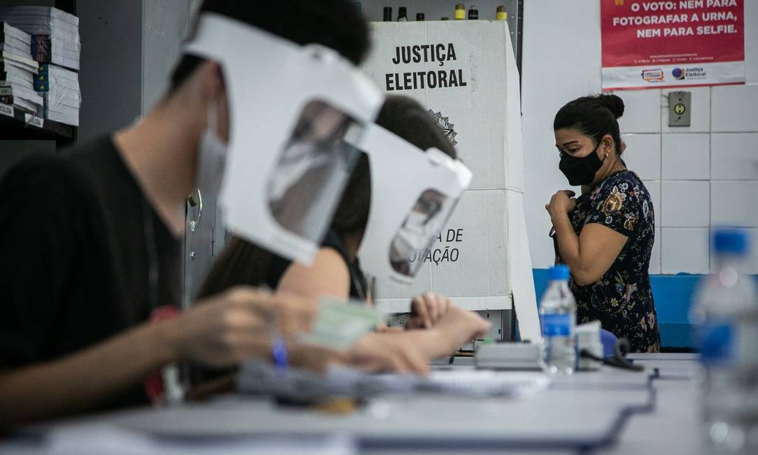 Officials wear a face shield and protective mask while working in the first round of the municipal elections, in Ciep Ayrton Senna, in Rocinha, South Zone of Rio Photo: Hermes de Paula / Agência O Globo