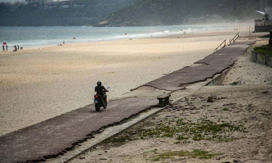 Motociclista no calçadão sem conservação e tomado por buracos em São Conrado: praia coleciona riscos aos frequentadores Foto: Hermes de Paula / Agência O Globo