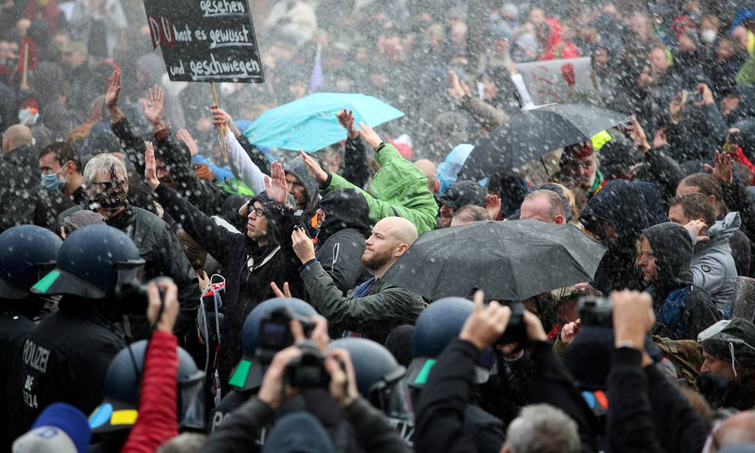 Manifestantes no Portão de Brandemburgo, em Berlim, na Alemanha, criticam as medidas da chanceler Angela Merkel para conter a disseminação da Covid-19 Foto: Christian Mang / Reuters