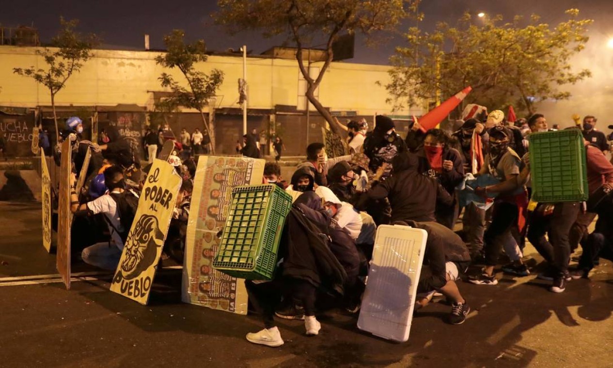 Manifestantes improvisam proteção contra disparos da polícia de choque Foto: SEBASTIAN CASTANEDA / REUTERS - 14/11/2020