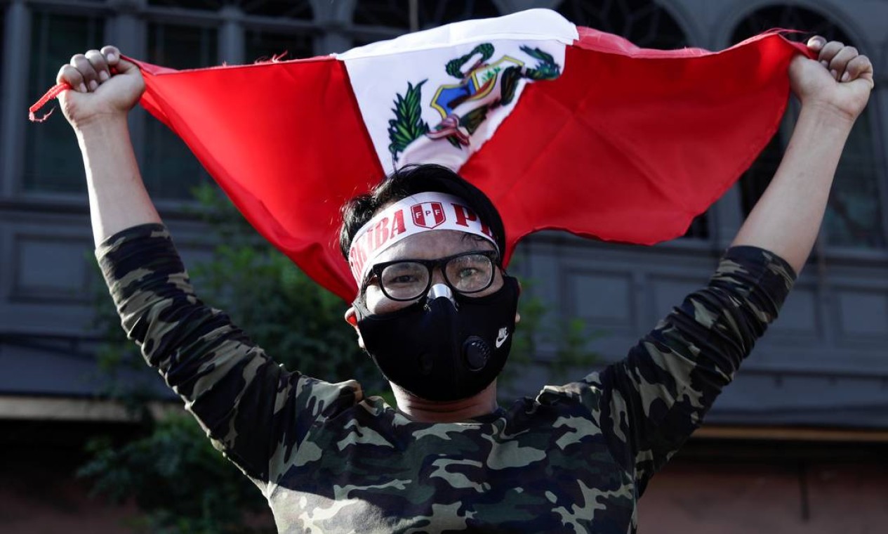 Manifestante comemora com bandeira do Peru a renúncia de Manuel Merino Foto: STRINGER / REUTERS - 15/11/2020