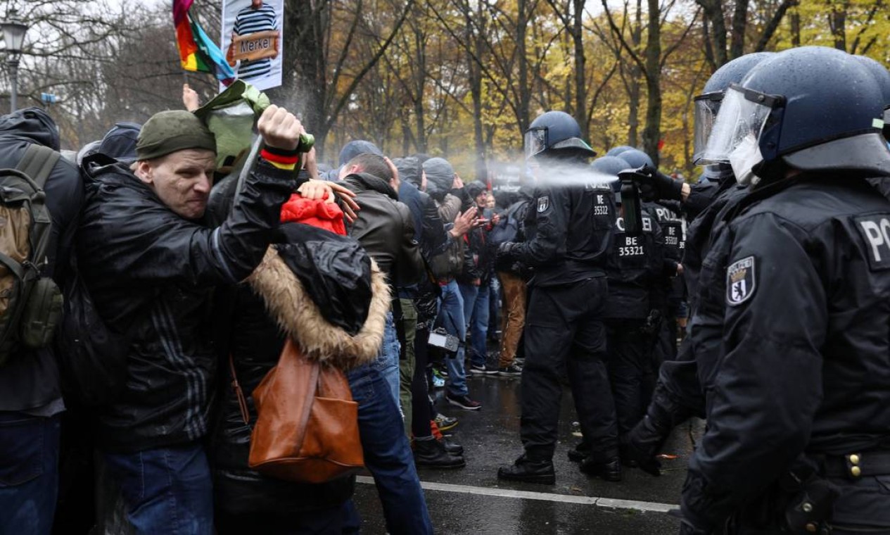 Policial usa spray de pimenta contra manifestantes, próximo à Porta de Brandenburgo em Berlim Foto: CHRISTIAN MANG / REUTERS