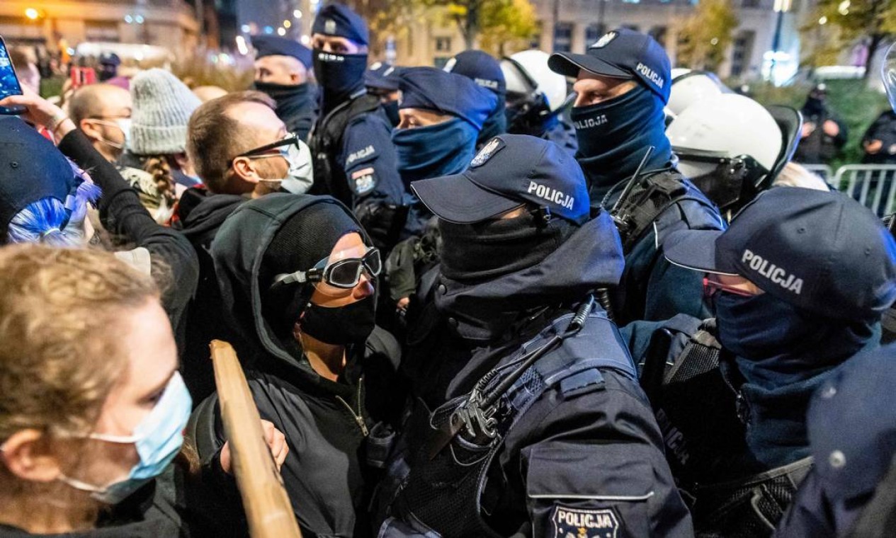 Manifestantes pró-escolha enfrentam polícia polonesa, em Varsóvia Foto: WOJTEK RADWANSKI / AFP