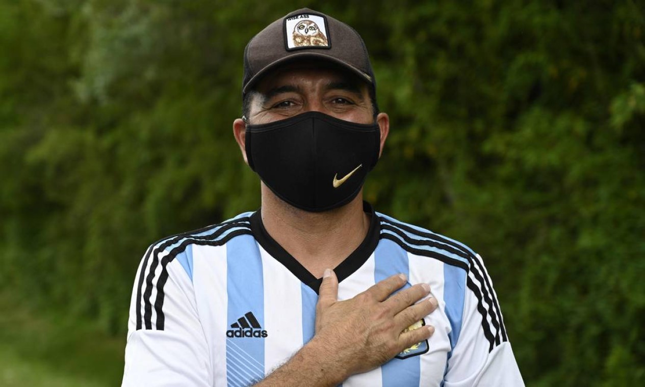 Torcedor presta reverência a Maradona, em frente ao condomínio onde fica a casa do craque argentino, em Benavidez, na província de Buenos Aires Foto: JUAN MABROMATA / AFP