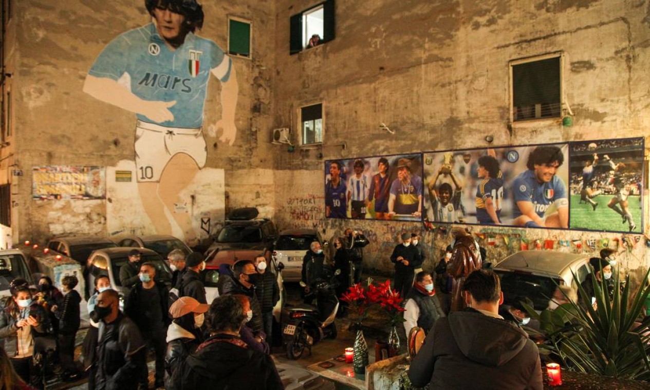Pessoas se reúnem no topo do Quartieri Spagnoli em Nápoles em 25 de novembro de 2020, perto de um mural de 1990 representando a lenda do futebol argentino Diego Maradona, para lamentar o anúncio da morte de Maradona Foto: CARLO HERMANN / AFP