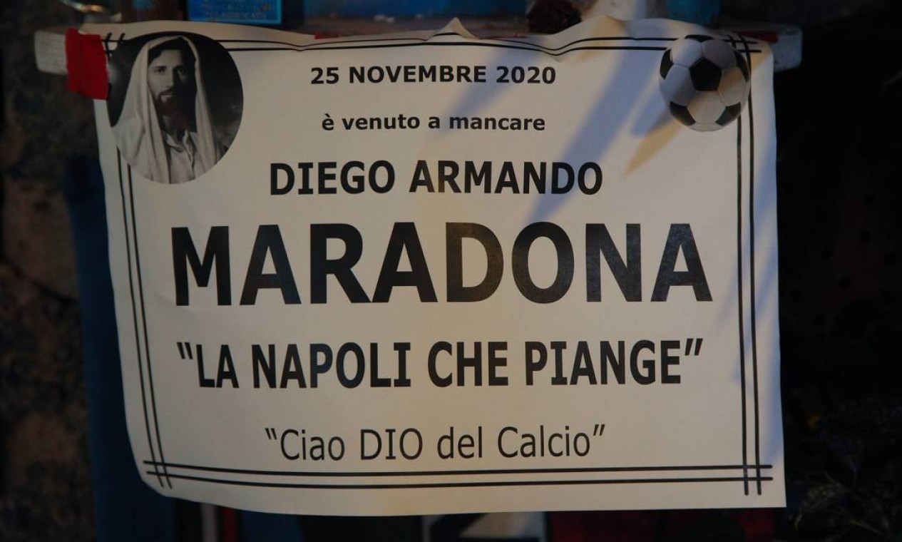 "Maradona faleceu em 25 de novembro de 2020. Napoli está chorando, adeus ao Deus do Futebol", diz a placa no topo do Quartieri Spagnoli, em Nápoles, Itália Foto: CARLO HERMANN / AFP