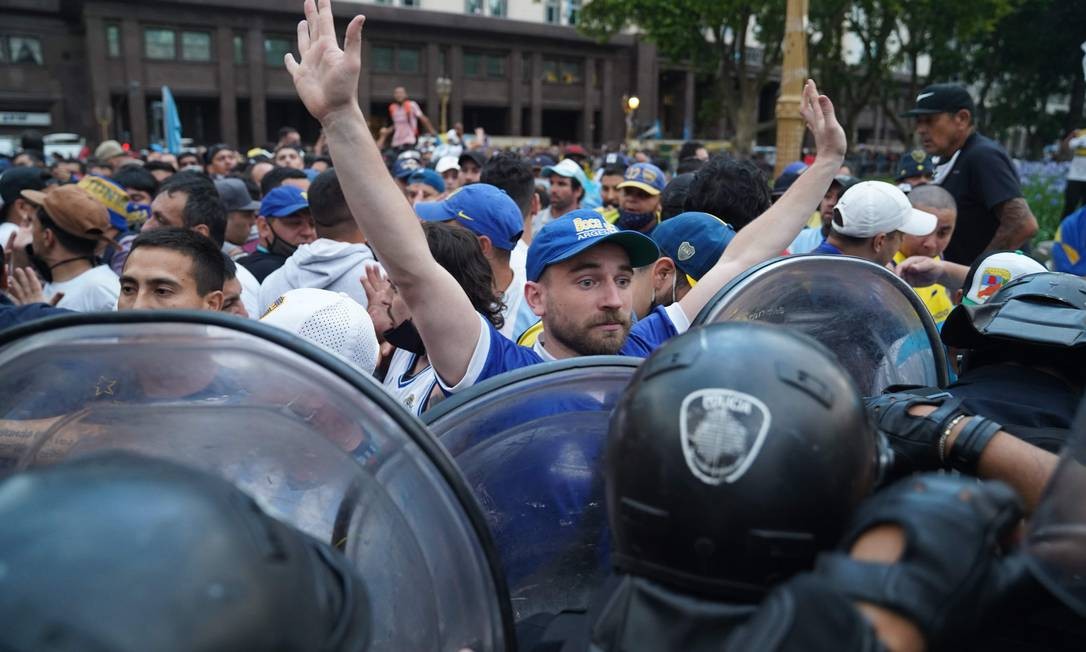 Polícia tenta conter multidão de fãs que esperam para rpestar última homenagem ao craque argentino Foto: IVAN PISARENKO / AFP