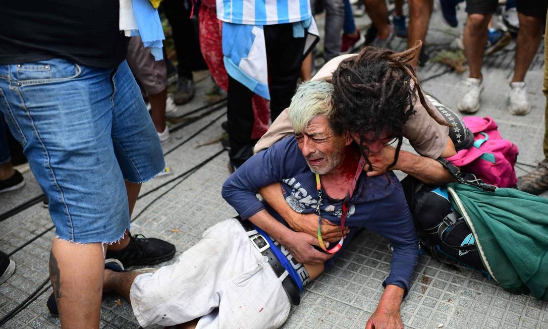 Fã chora após ser ferido durante brigas com a polícia enquanto esperava para entrar na Casa Rosada para homenagear a falecida lenda do futebol Diego Armando Maradona, em Buenos Aires Foto: RONALDO SCHEMIDT / AFP