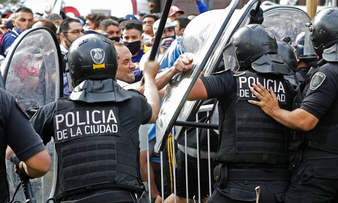 Fãs de Diego Maradona entram em conflito com policiais em frente à Casa Rosada, local do velório da lenda do futebol, que morreu nesta quarta-feira, em Buenos Aires, Argentina Foto: ALEJANDRO PAGNI / AFP