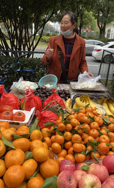 Zhou vende frutas perto do antigo mercado de frutos do mar onde o vírus teria se manifestado pela primeira vez Foto: Marcelo Ninio / O Globo