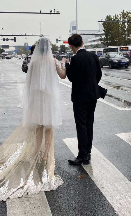 Casal faz fotos de casamento nas ruas da cidade, que voltou à vida normal após controlar os casos de coronavírus Foto: Marcelo Ninio / O Globo