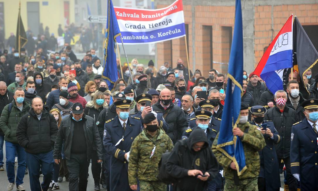Manifestantes croatas participam de uma passeata em Vukovar durante cerimônia para marcar o 29º aniversário da queda de Vukovar para as forças sérvias Foto: - / AFP/18-11-2020