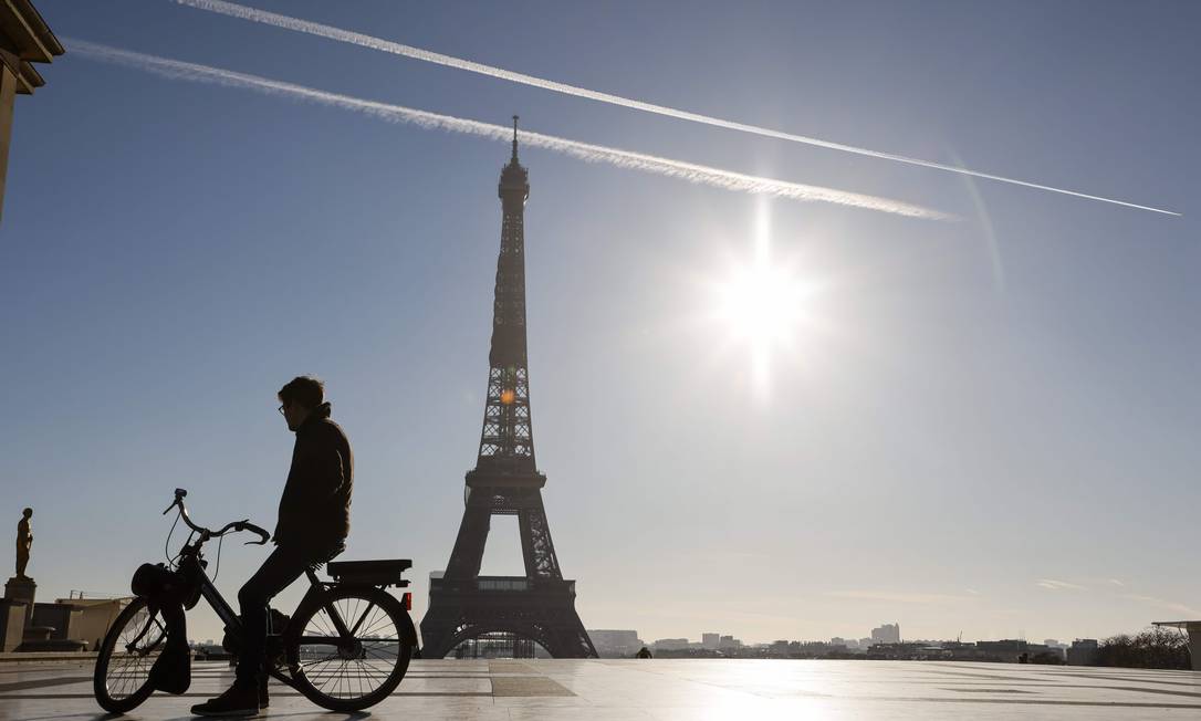 Homem pedala sua bicicleta em frente à Torre Eiffel, na Praça do Trocadero em Paris Foto: LUDOVIC MARIN / AFP/18-11-2020