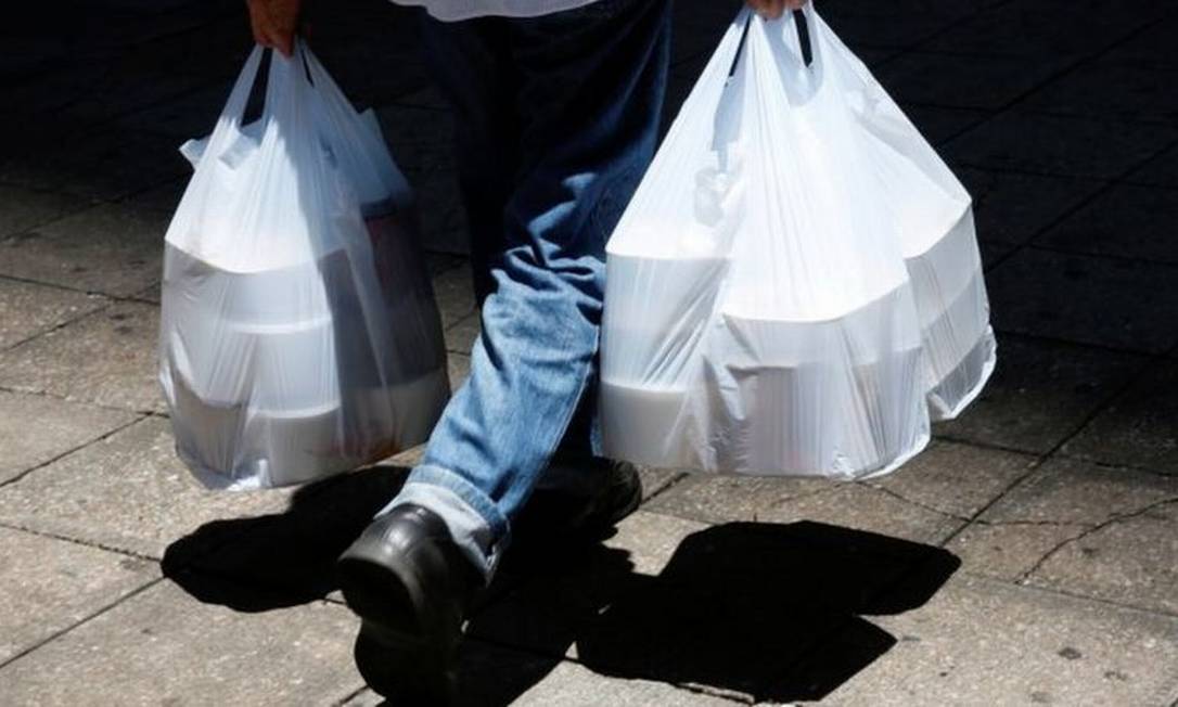 Homem buscando comida em meio à pandemia; delivery, comércio eletrônico e materiais hospitalares descartáveis fizeram uso de plástico explodir Foto: Reuters