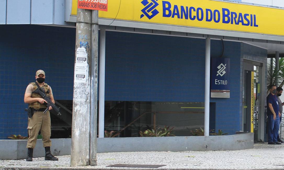 Policial faz a segurança de agência do Banco do Brasil em Criciúma assaltada por bando de pelo menos 30 criminosos Foto: GUILHERME HAUN / AFP
