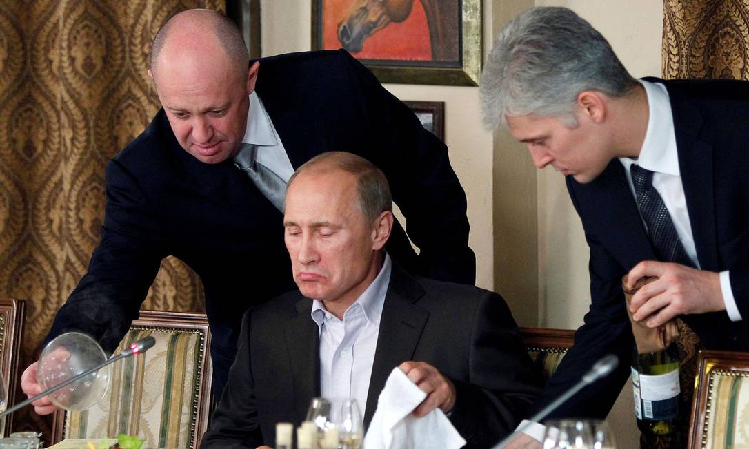 Yevgeny Prigozhin (à esquerda) serve um prato de comida a Putin em 2011 em seu restaurante em Moscou Foto: REUTERS