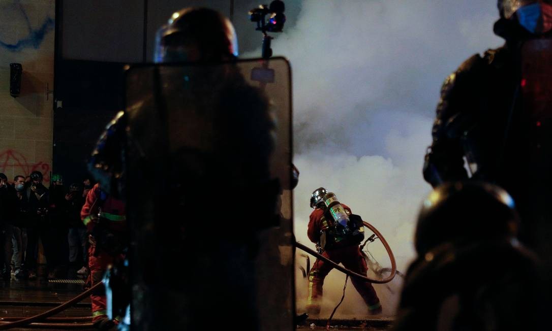 A firefighter puts out a fire during a demonstration against police violence in Paris Photo: GEOFFROY VAN DER HASSELT / AFP