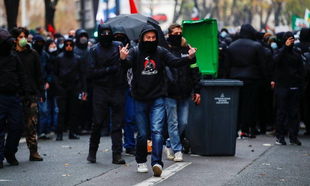 A protester gestures during a protest in Paris.  The demonstration began with thousands of people marching peacefully through the capital, holding banners that read 