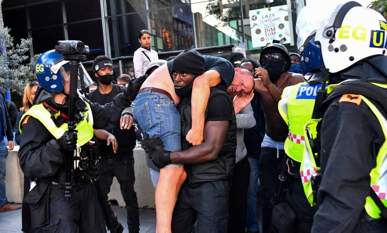 Patrick Hutchinson, um manifestante negro, socorre um contra-manifestante branco ferido, perto da estação de Waterloo, durante um protesto Black Lives Matter, em Londres, em 13 de junho Foto: DYLAN MARTINEZ / REUTERS - 13/06/2020