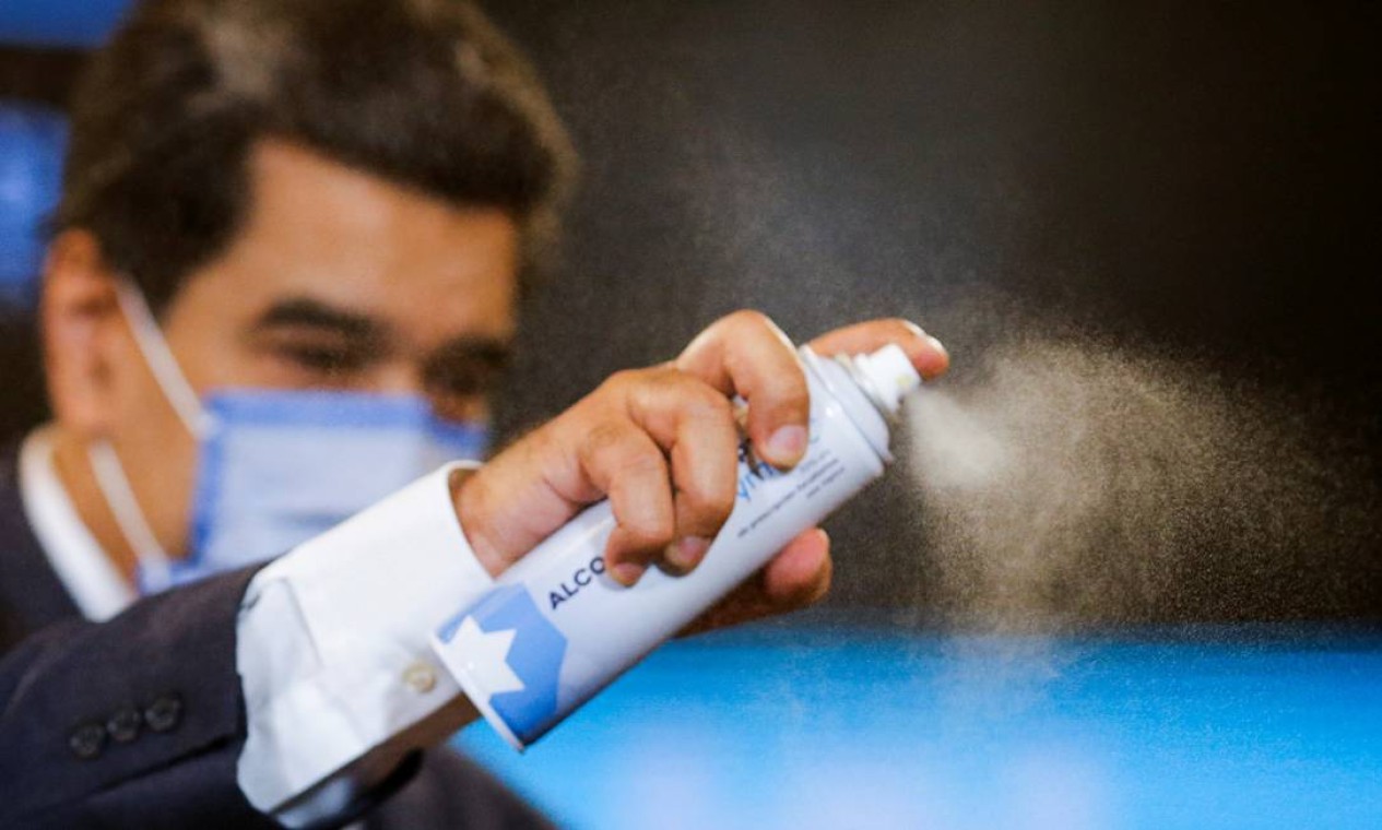 O presidente venezuelano Nicolas Maduro usa spray desinfetante após entrevista coletiva após a vitória do Partido Socialista no poder nas eleições legislativas boicotadas pela oposição em Caracas, Venezuela Foto: MANAURE QUINTERO / REUTERS