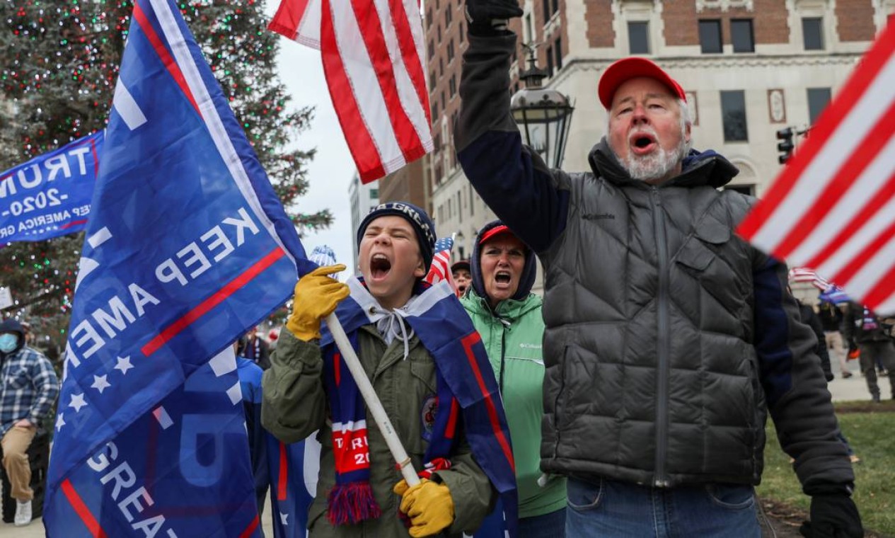 As pessoas reagem ao participar de um evento para mostrar seu apoio ao presidente dos EUA, Donald Trump, em Lansing, Michigan, EUA Foto: EMILY ELCONIN / REUTERS