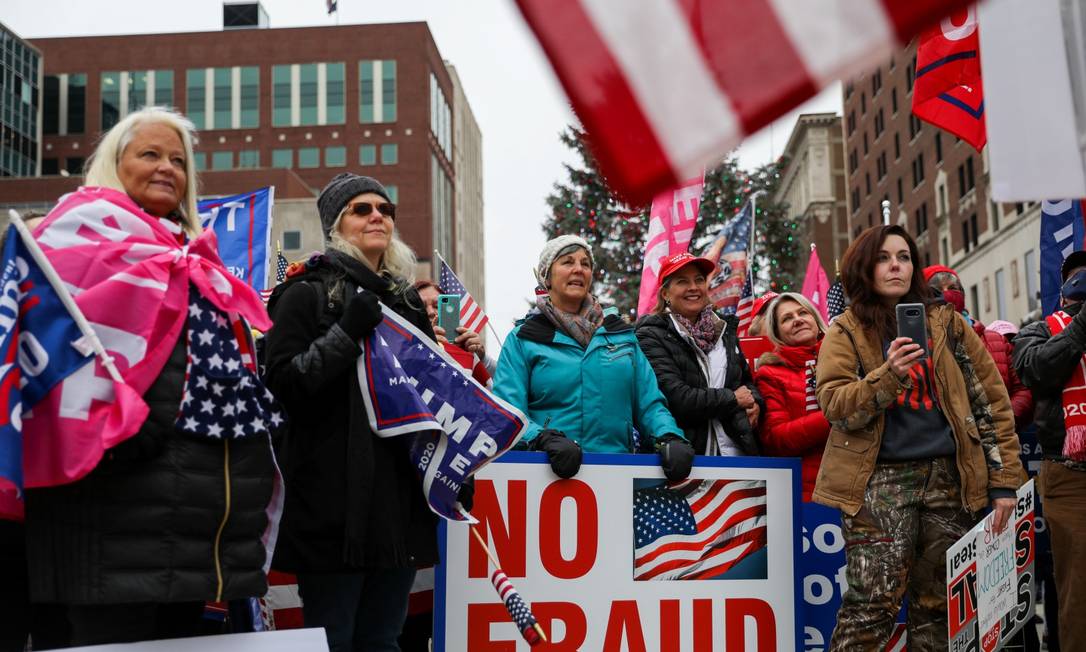 Eleitoras de Trump participam de evento em apoio ao presidente em Lansing, Michigan, segurando cartaz com a frase "sem fraude" Foto: EMILY ELCONIN / REUTERS
