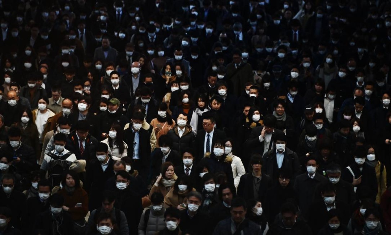 Fevereiro - Multidão de passageiros usam máscaras durante a hora do rush matinal na estação ferroviária de Shinagawa em Tóquio, Japão. O índice Nikkei havia despencado quase três por cento na abertura, devido à preocupação com o impacto econômico do surto de coronavírus Foto: CHARLY TRIBALLEAU / AFP - 28/02/2020