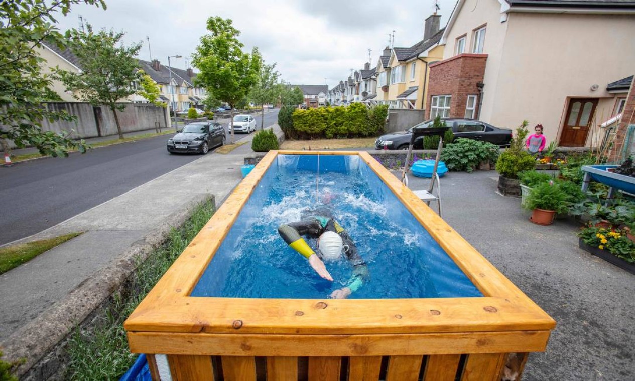 Junho - O atleta paralímpico irlandês Leo Hynes, que é legalmente cego, improvisou piscina no quintal em Tuam, Co Galway, oeste da Irlanda, mara treintar durante a quarentena. Amarrado a uma corda elástica ele treina longas distâncias sem sair do lugar Foto: PAUL FAITH / AFP - 18/06/2020