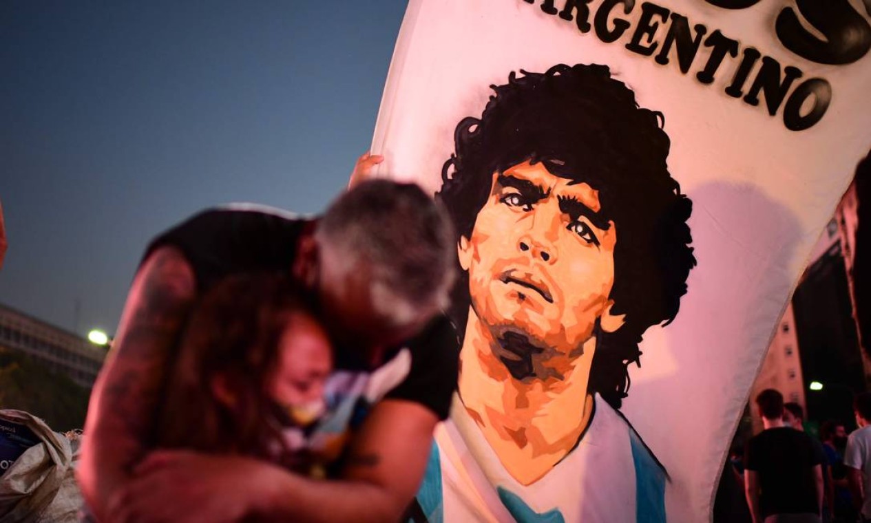 Novembro - Pai e filha, fãs da lenda do futebol argentino Diego Maradona, choram ao se reunirem no Obelisco para prestar homenagem no dia de sua morte na capital Buenos Aires Foto: RONALDO SCHEMIDT / AFP - 25/11/2020